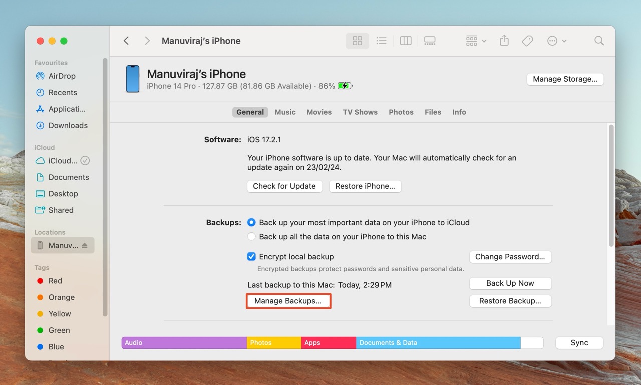 The Finder window on a Mac, with the device summary for "Manuviraj’s iPhone" shown, and the "Manage Backups..." option highlighted, indicating where the user can manage their iPhone backups.