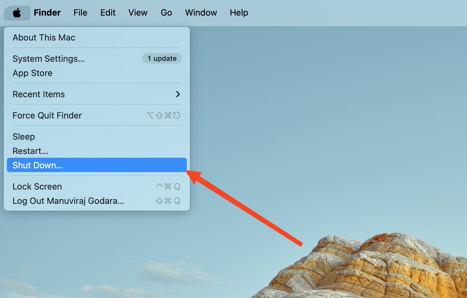 A Finder menu on a Mac with an arrow pointing to the "Shut Down..." option.